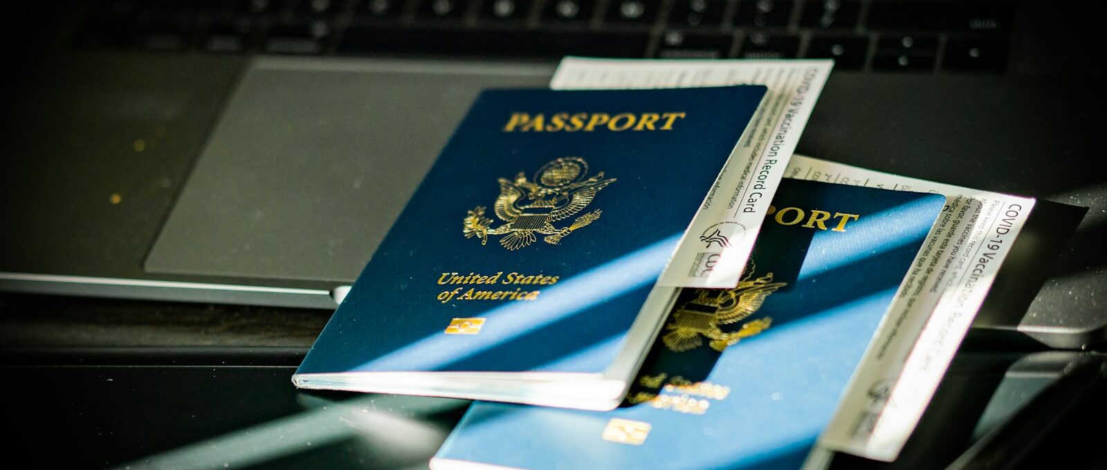 a passport sitting on top of a computer keyboard